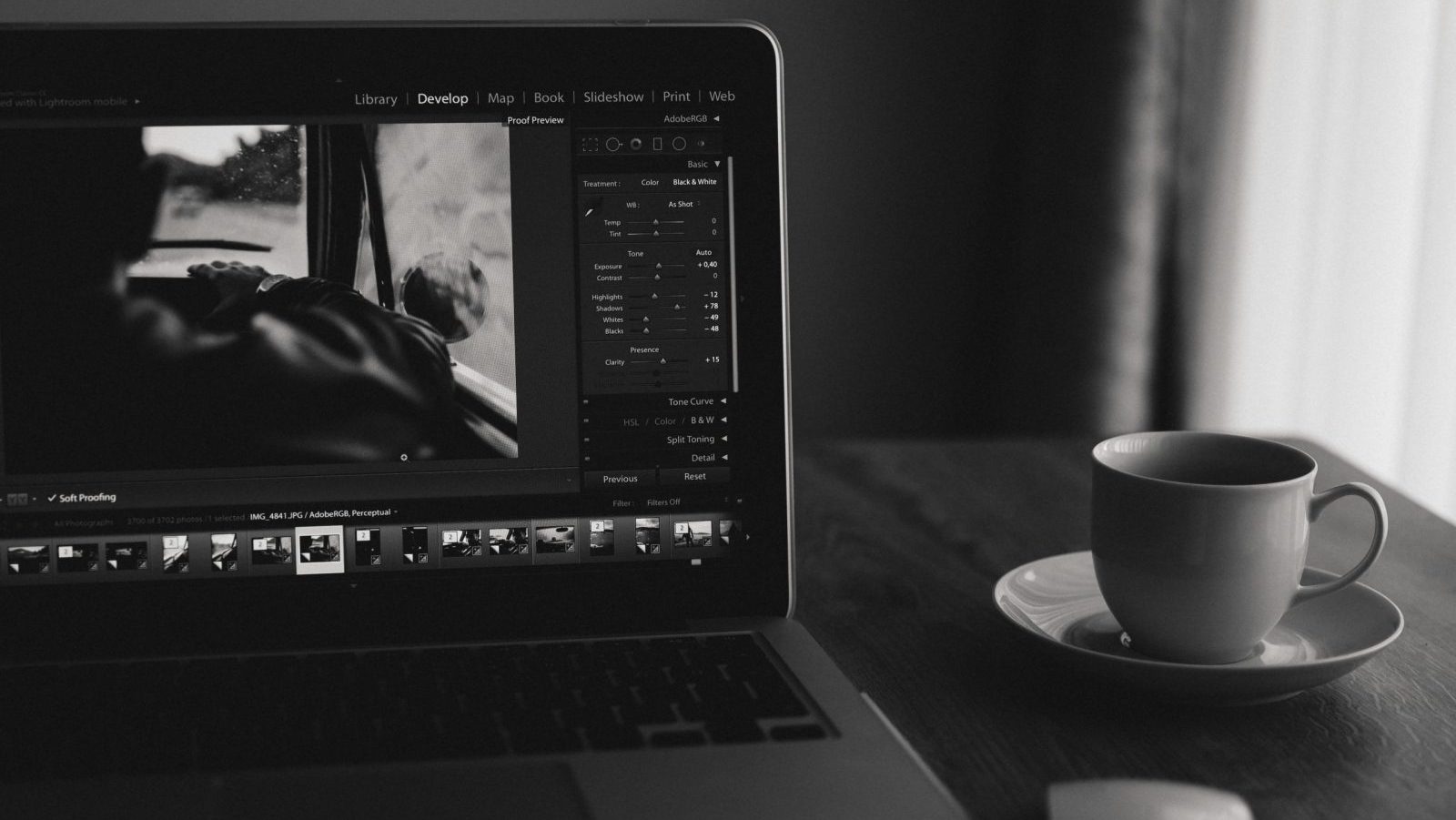 Minimalist black and white photo of a laptop with coffee. Ideal for home office themes.