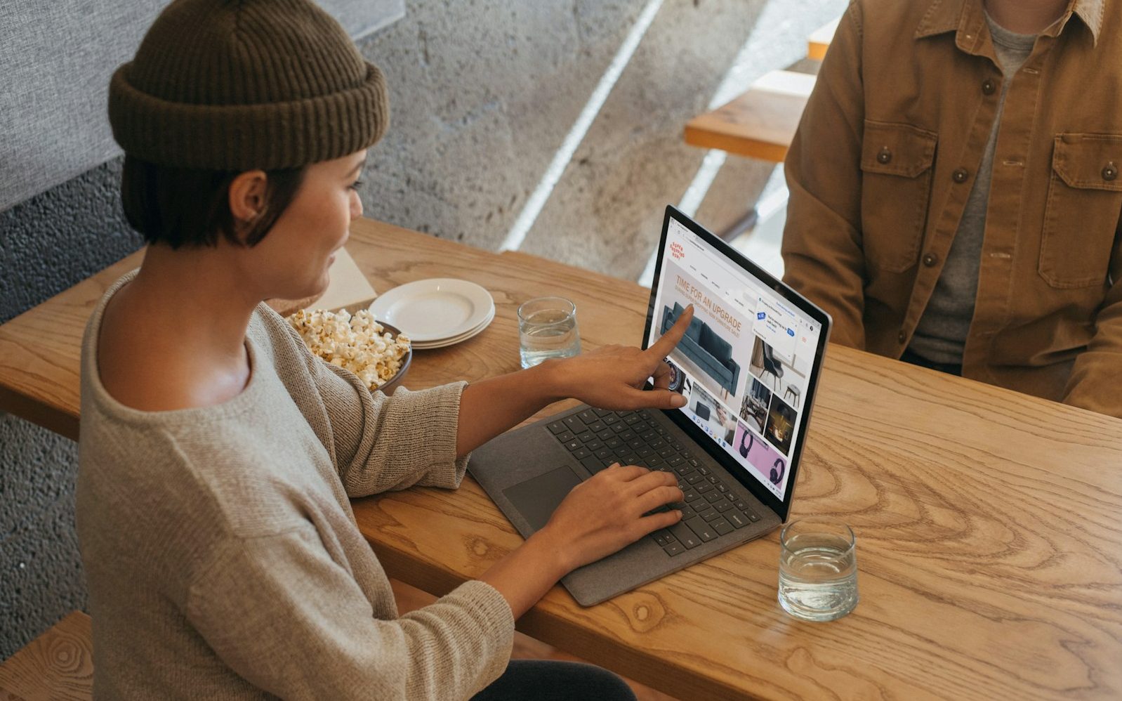 Two people sitting across from each other in an office working on a Surface laptop